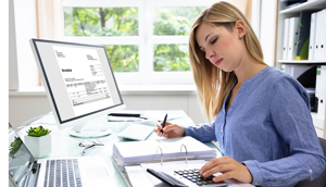 a woman sitting at a desk with a calculator